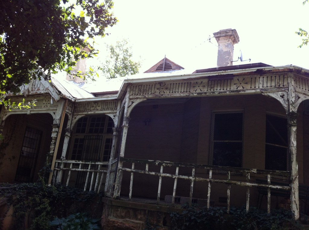 Intricate woodwork details on the verandah of this rundown house